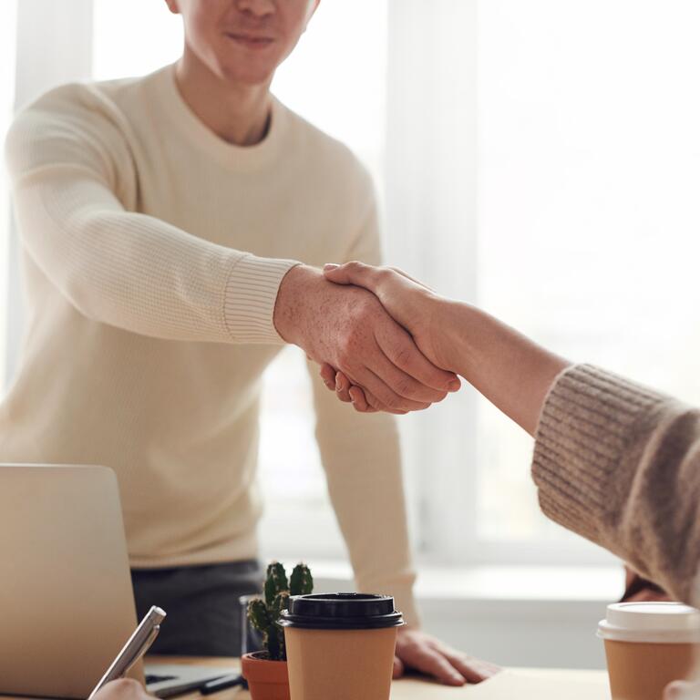 two people shaking hands in a professional setting